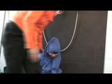 Jill in a shiny blue rainsuit tied,hooded and gagged by Simone under the shower (Video)