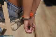 Hot jeans girl cuffed on a chair