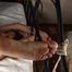 Ballgagged barefoot topless Cynthia in white panties, tied on the bed with her legs pulled up and tied wide-spread, is being played with vibrator by camera man