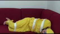 Mara tied and gagged with tape on a sofa wearing a sexy shiny yellow rainwear combination (Video)