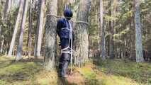Sebastien breathplay tied up in a puffer jacket among the trees.
