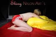 Sexy Sonja posing for you in a red shiny nylon shorts and a tshirts and then she takes it off and plays with the bedding (Pics)