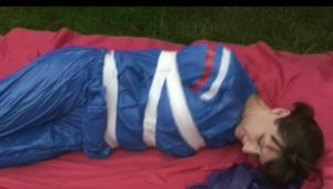 a video with Nicole tied and gagged in a shiny blue PVC suit