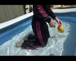 Mara wearing a shiny black/pink adidas training suit playing with water in the pool (Video)