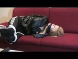 Samantha tied and gagged on a red sofa wearing a shiny black rainpants and a jacket (Video)