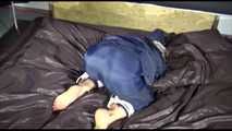 Sexy Sandra wearing a sexy blue shiny nylon pants and a sexy blue rain jacket tied and gagged with ropes and a cloth gag on a bed (Video)