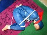 one of our archive girls tied and gagged in a shiny nylon rainsuit