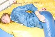 Alina wearing a sexy shiny rainwear suit in blue lolling on bed cuffed (Pics)