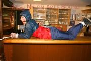 An archive girl tied and gagged on a bar wearing shiny nylon rainwear (Pics)