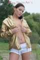Watching out beautiful archive girl wearing a white shiny nylon shorts and a golden rain jacket posing outdoor (Pics)