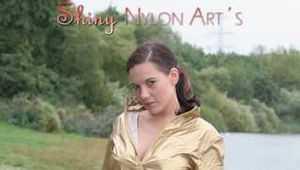 Watching out beautiful archive girl wearing a white shiny nylon shorts and a golden rain jacket posing outdoor (Pics)