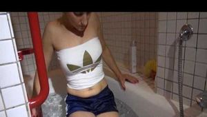 Watching Sandra wearing a sexy blue shiny nylon shorts and a top while playing with water in her bath tub (Video)
