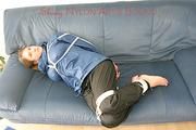 Katharina tied, gagged and hooded (breath control) on a sofa wearing sexy shiny nylon rainwear (Pics)