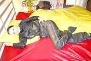 Lucy preparing her bed and enjoys it wearing sexy black rainwear (Pics)