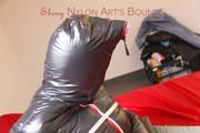 Jill tied, gagged and hooded on a bed wearing a grey rain pants and a black downjacket with closed zip for breath control play (Pics)
