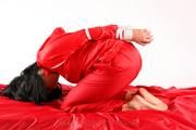 Jessy tied in a shiny nylon rainsuit