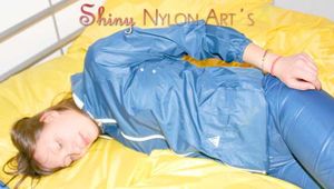 Alina wearing a sexy shiny rainwear suit in blue lolling on bed cuffed (Pics)