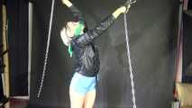 Watching sexy Sonja wearing a sexy lightblue shiny nylon shorts and a black shiny nylon rain jacket being tied and gagged overhead with cuffs, chains and a clothgag (Video)