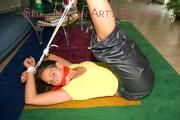 Stella tied and gagged on the floor wearing a shiny nylon rain pants (Pics)