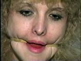 28 YR OLD BEAUTIFUL DOE EYED REBECCA IS MOUTH STUFFED, CLEAR WHITE TAPE GAGGED, RUBBER BAND BALL-GAGGED, HANDCUFFED & BOUND WITH TAPE (D46-9)