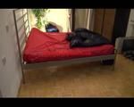 Lucy in bed wearing a blue shiny nylon shorts and a black rain jacket (Video)