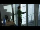 Enni with black shiny nylon shorts and rain pants and a rain jacket over naked skin smoking a cigarette (Video)