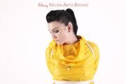 Jill tied and gagged in a shiny yellow rainsuit and rubber boots