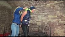 Pia tied and gagged on a princess bed in an old cellar wearing a sexy black rain pants and a darkblue/green down jacket (Video)