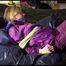 Pia tied and gagged on a bed with shiny nylon cloth wearing a supersexy purple rainjacket and rainpants (Video)