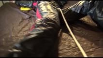 Liz tied and gagged on a bed wearing an oldschool black/red shiny nylon downwear combination (Video)