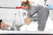 Simone in an shiny grey pvc sauna suit tied and gagged by Sophie in the bath tub (pics)