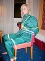 Blonde archive girl tied and gagged in an green shiny nylon rainsuit on a chair (Pics)