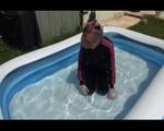 Mara wearing a shiny black/pink adidas training suit playing with water in the pool (Video)
