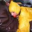 Stella tied and gagged in a shiny yellow rainsuit