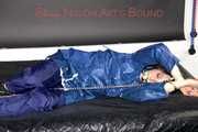 Lucy tied with cuffs overhead and gagged with a clothgag wearing sexy blue rain pants and a raincoat (Pics)