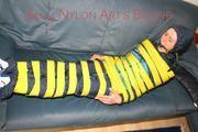 Katharina tied and gagged with tape on a sofa wearing shiny rainwear (Pics)