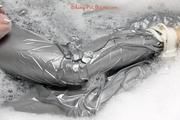 Simone in an shiny grey pvc sauna suit tied and gagged by Sophie in the bath tub (pics)