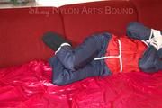 Lucy tied, gagged and hooded with ropes on a sofa wearing a sexy blue/red rainwear combination (Pics)