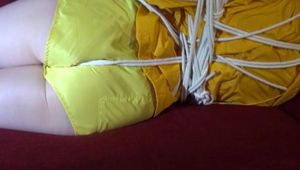 Lucy tied and gagged on a red sofa wearing a sexy yellow shiny nylon shorts and a yellow rain jacket (Video)