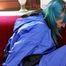 Mara tied and gagged on a red sofa wearing a sexy shiny lightblue rainwear (Pics)