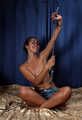 Topless barefoot Christy in jeans shorts, cuffed with steel handcuffs and legcuffs, poses for the camera