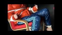 Pia tied and gagged on a chair wearing a shiny orange downjacket (Video)