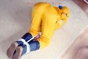 Katharina tied and gagged in a yellow rainsuit