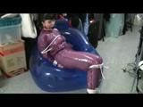 Video with Jill tied and gagged in a shiny purple semi transparent PVC suit