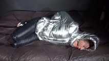 Watching sexy Sandra being tied and gagged on a bed with ropes and a ballgag wearing a supersexy shiny black nylon pants and a silver down jacket (Video)
