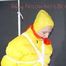 Mara wearing a sexy black rain pants, red rubber boots and a yellow down jacket tied and gagged with ropes and a cloth gag on the ceiling (Pics)