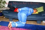 Katharina tied and gagged on a sofa wearing blue shiny downwear (Pics)