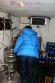 Jill posing in a cooling room wearing a shiny nylon rainpants and a down jacket (Pics)
