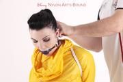 Jill tied and gagged in a shiny yellow rainsuit and rubber boots