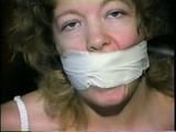 25 YR OLD CHARLENE IS WRAP GAGGED & CHAIR TIED TO A CHAIR WITH WHITE CLOTH MEDICAL TAPE (D47-14)